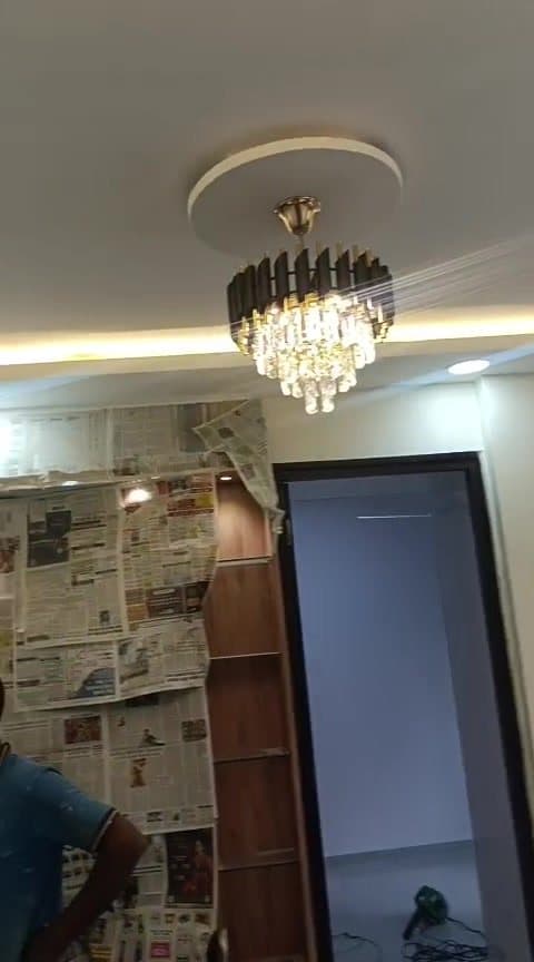 Crystal chandelier installed in a false ceiling with warm gold cove lighting