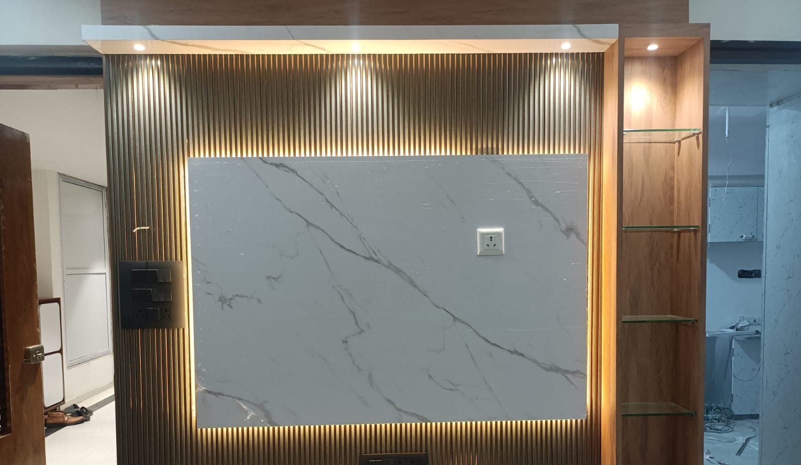 Backlit marble and steel TV feature wall with concealed cove lighting, installed by VRC Electrical