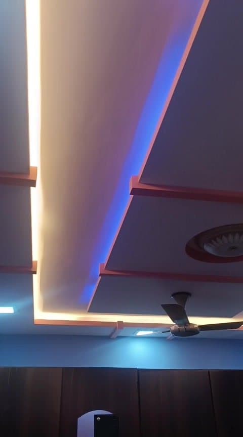 Multi-tier false ceiling with colour-changing RGB cove lighting cycling between blue and amber